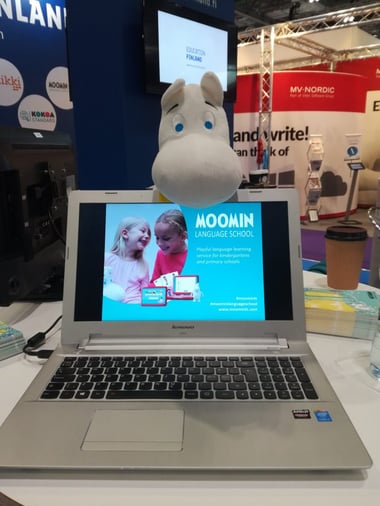 A laptop with Moomin Language School information and a Moomin toy