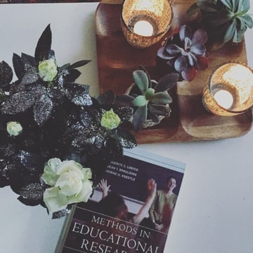 Methods in Educational Research book on a table with succulents and candles