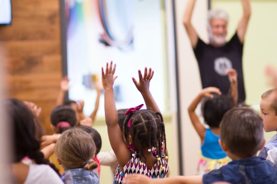 Group of children lift their arms up