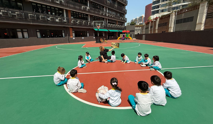 Kindergarten children listening to a story on the yard of Generations Kindergarten